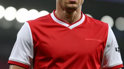 A close-up shot of a Derry City player in a red jersey with white sleeves, taken with a 50mm f/1.4 lens, with a shallow...
