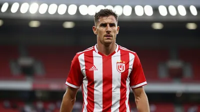 A 37-year-old winger with a determined expression, wearing a red and white striped football kit, walking into a stadium...