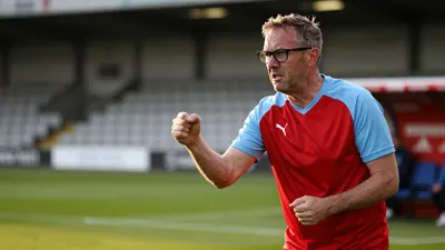 A 35-year-old, ruggedly-built, bespectacled assistant coach of Derry City, dressed in a plain red and sky blue polyester...