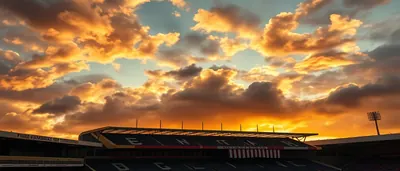 A tense stadium aisle at dusk, an anxious Derry City manager in a plain navy tracksuit clutching his teenage son’s hand...