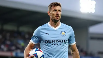 A tight action crop of a 40-year-old, tall, athletic-looking man in his Derry City jersey, with a determined expression...