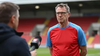 A 50-year-old, ruggedly-built, bespectacled, unassuming Derry City assistant coach, wearing a plain red and sky blue...