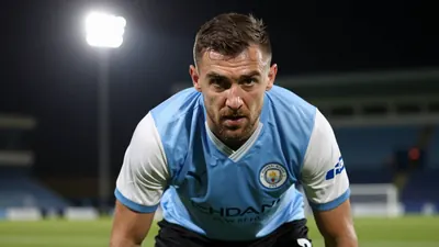 A close-up shot of an anonymous Derry City player, aged 30-40, with a rugged build, wearing a blue jersey with white...